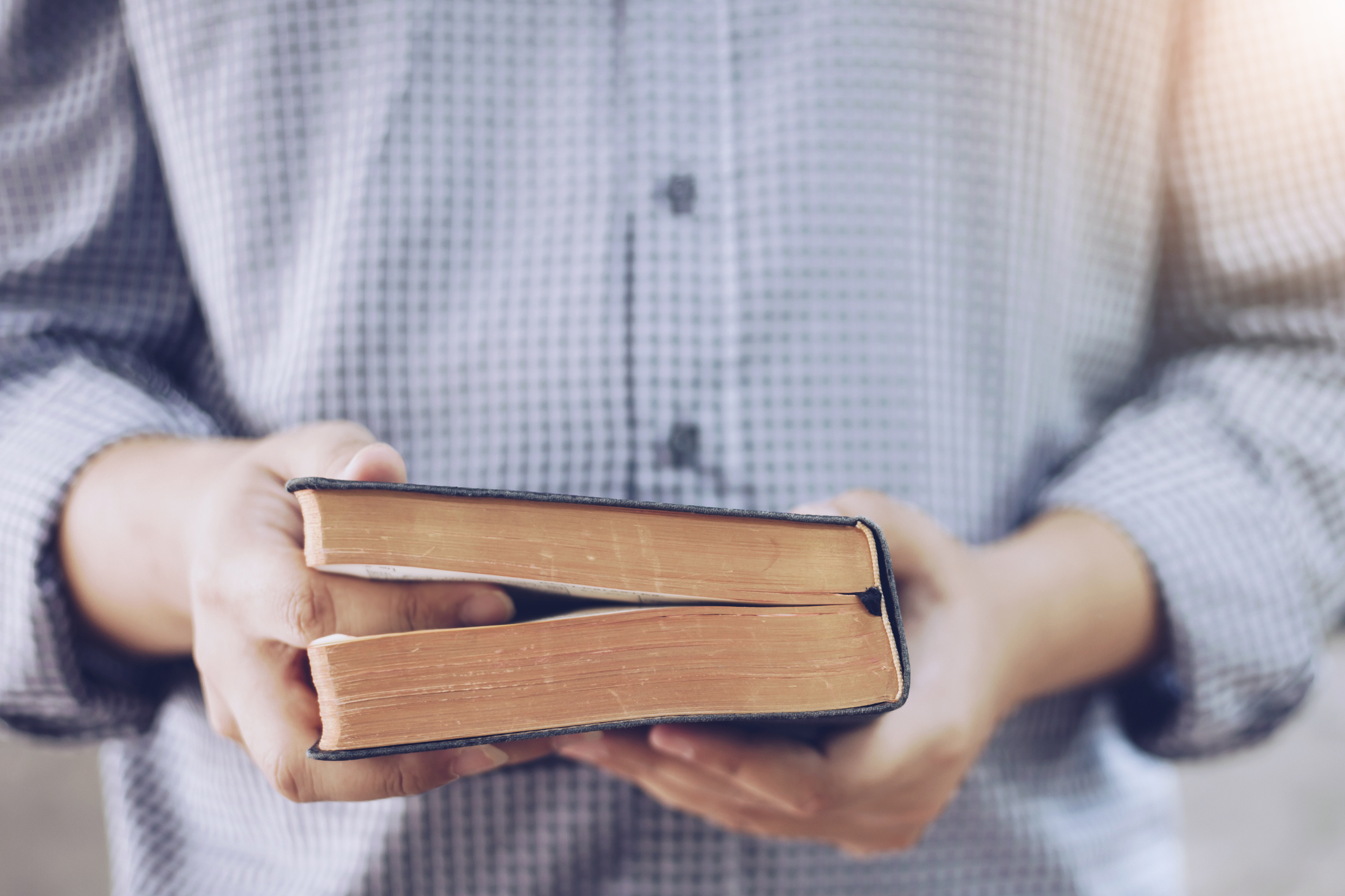 stock photo of man holding Bible with finger holding space in the text
