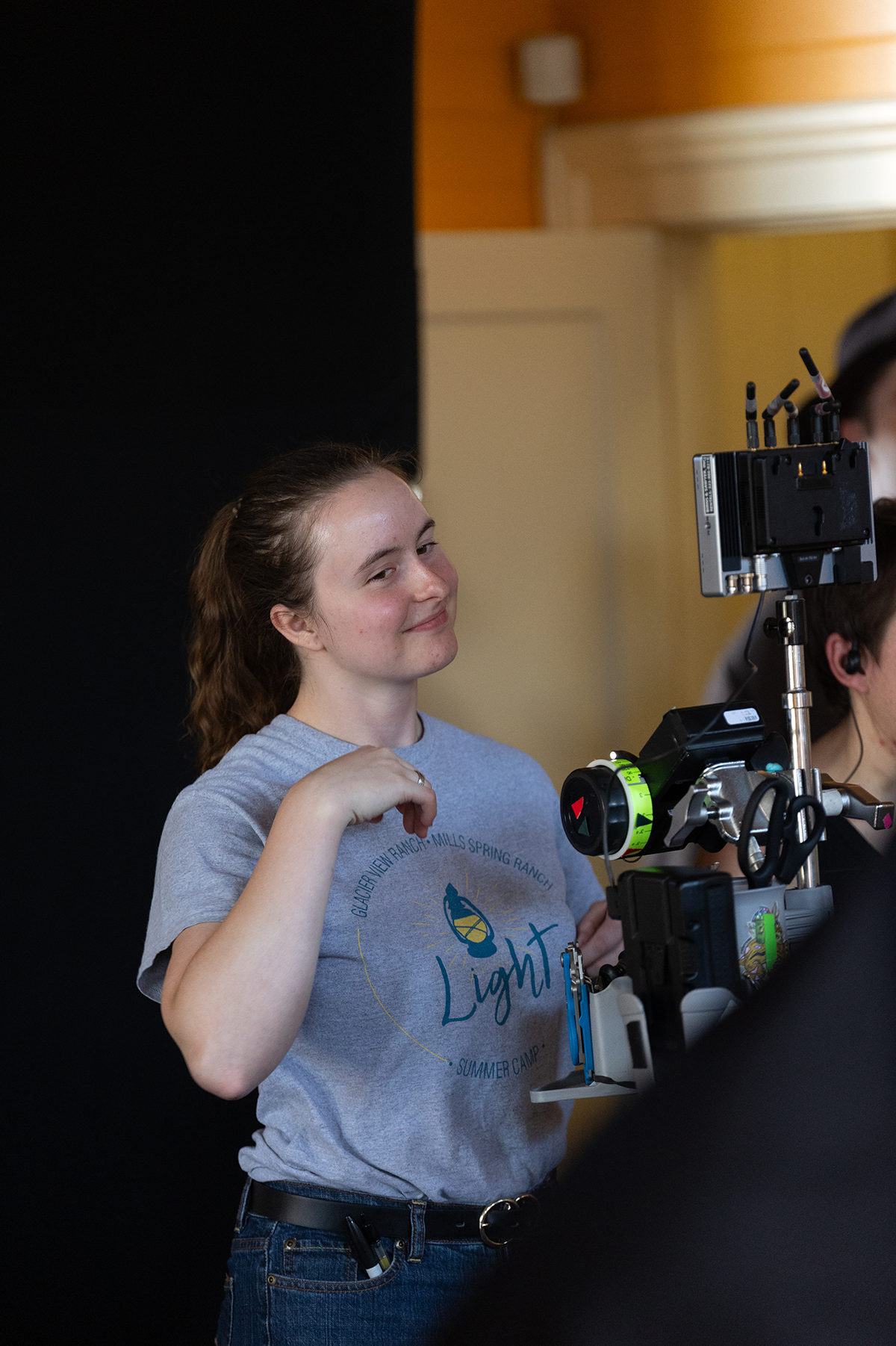 Smiling young woman behind a video camera