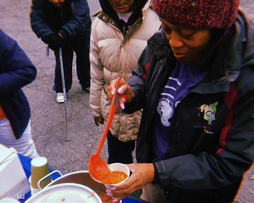 Gael Murray scoops soup to serve hungry residents of Baltimore, Maryland during Global Youth Day on Saturday, March 17