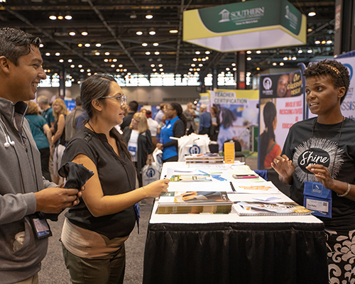 A representative of Encounter Bible Series discusses the organization’s resources with two attendees of the 2018 NAD Teachers’ Convention. 