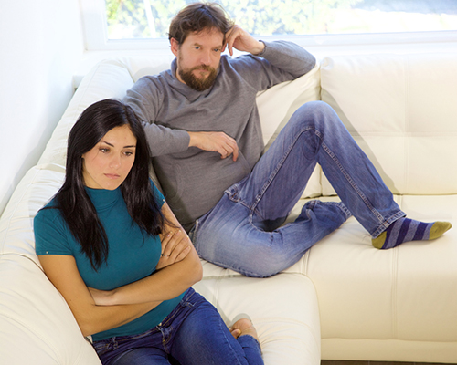married couple sitting on sofa after argument