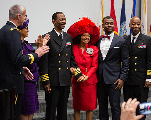 Washington Johnson, II poses with family and colleagues after receiving his new service dress coat, which reflects his new ranking. 