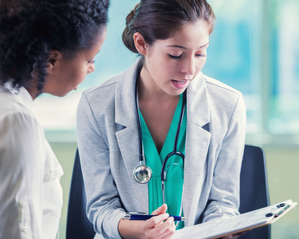 stock photo of female doctor helping patient with chart