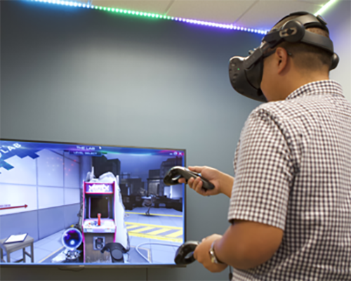 Religious studies major Gregory Jhanapin tries out a virtual reality video game in La Sierra University’s new virtual reality and artificial intelligence lab. 