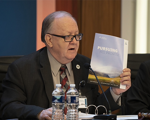 Daniel R. Jackson, holds up the program for the 2019 Year-End Meeting of the North American Division. 