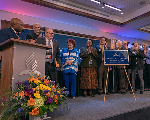 NAD leaders applaud Daniel R. Jackson, president of the NAD, after the unveiling a wall plaque bearing the new name of the building’s executive boardroom — “Daniel R. Jackson Executive Boardroom.” 