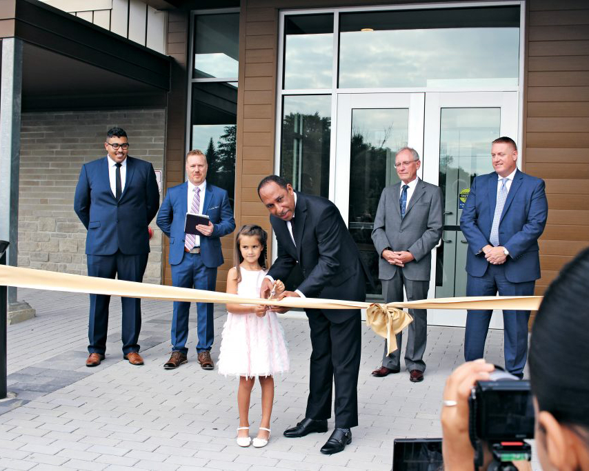 Mansfield Edwards and Eden M. cutting the ribbon, as Really Living youth pastor Benton Lowe; lead pastor, Francis Douville; SDACC president, Mark Johnson; and guest speaker, Dan Linrud look on.