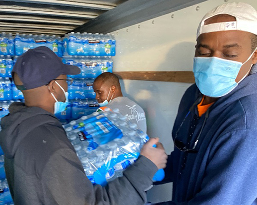Oakwood University Church and Breath of Life workers carry cases of water