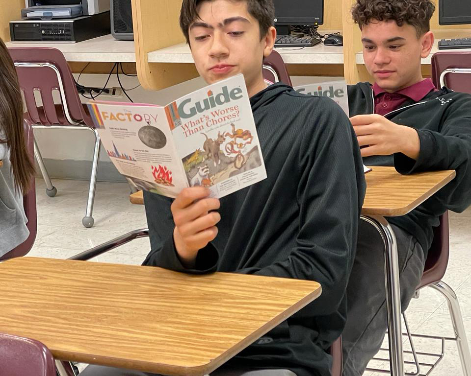 two students reading guide magazine