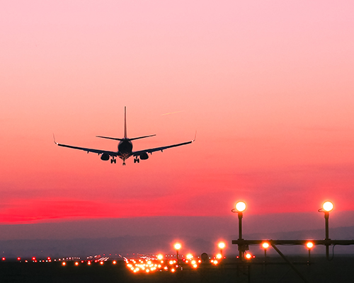 airplane landing at sunset stock photo