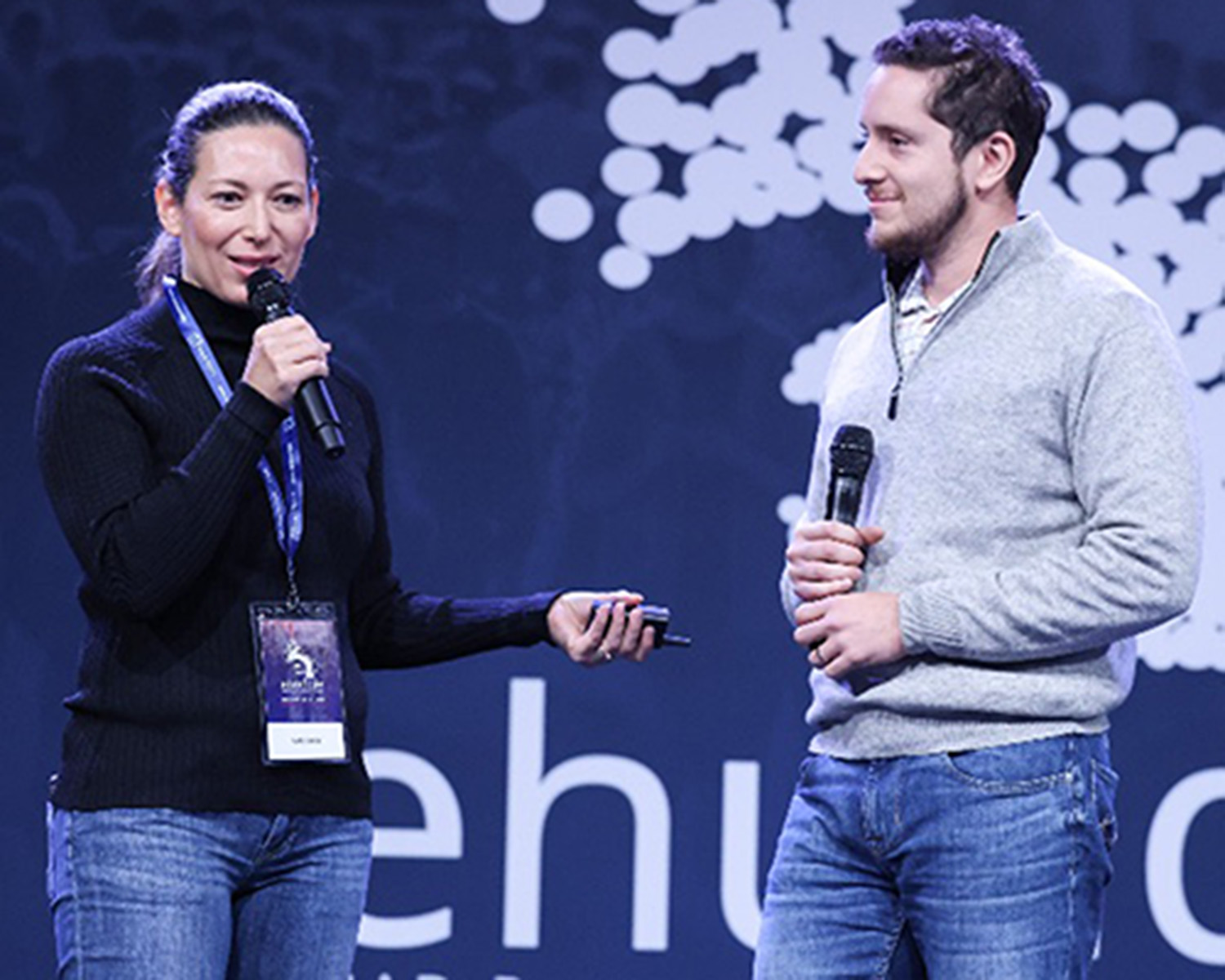 Man and woman speaking into microphone.