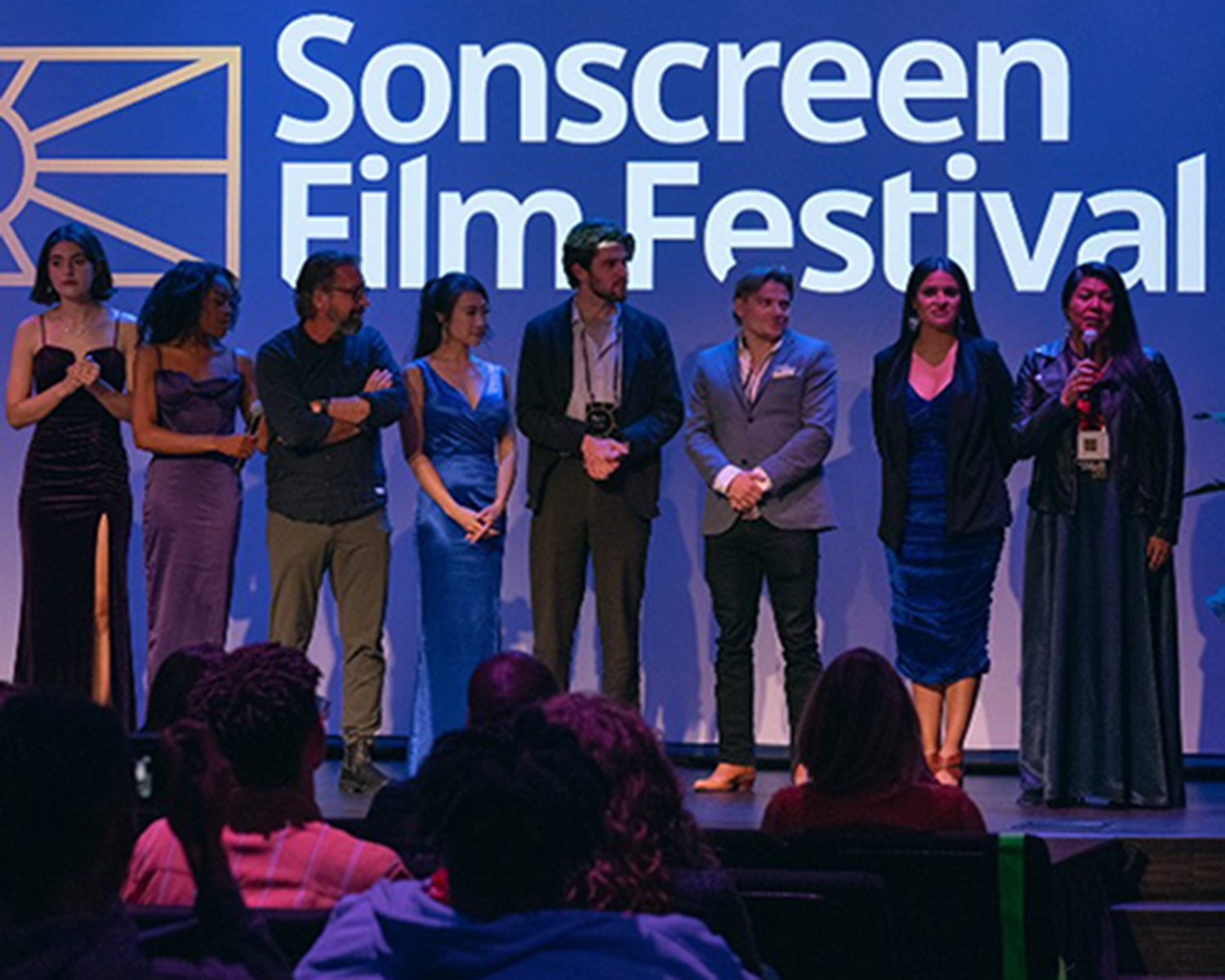 Group of people standing on the stage at a film festival.