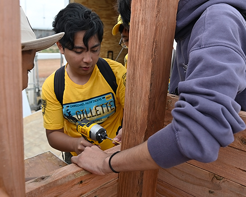 Teenage boys build a grow box for the community. 