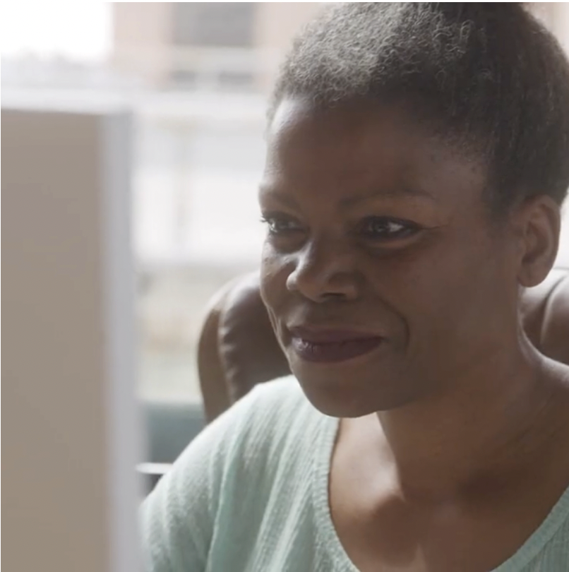 A smiling lady looking at the computer