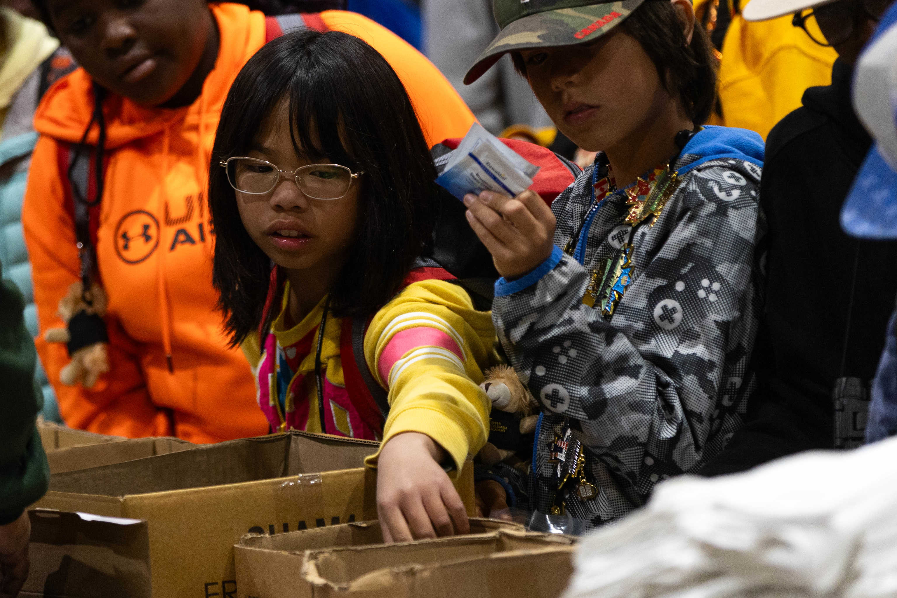 Children of different ethnic groups put together hygiene kits for the community. 