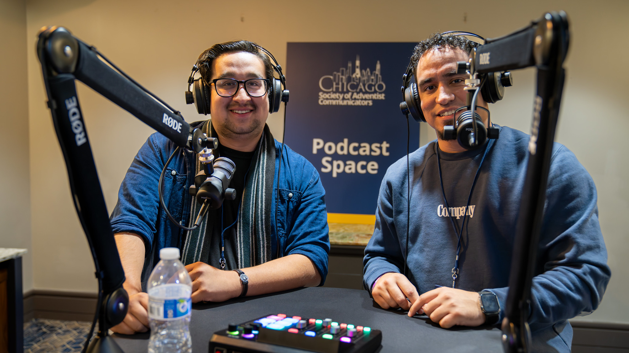 Two young men use the SAC podcast station at the 2024 convention