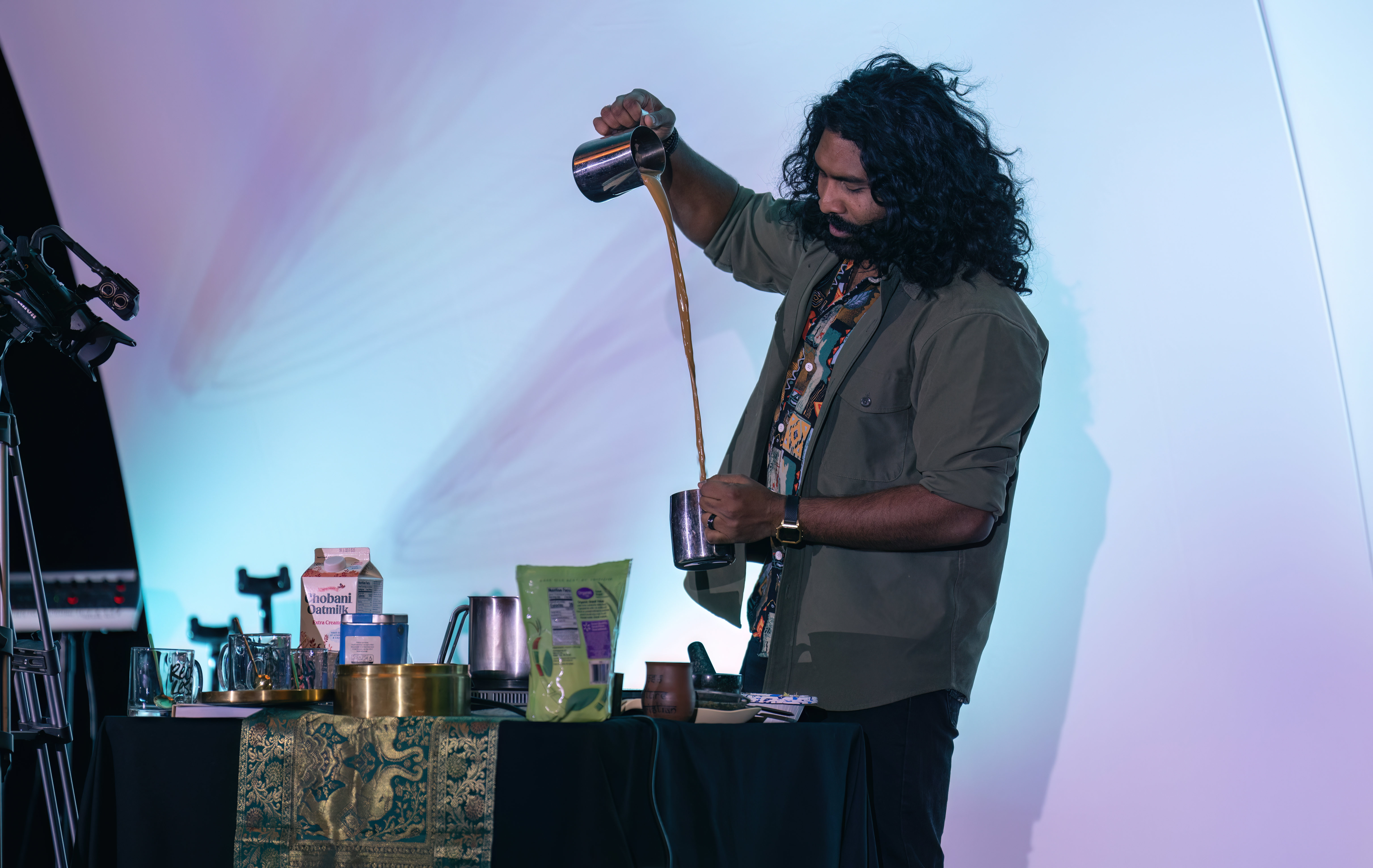 Indian man pours chai from one cylinder to the other