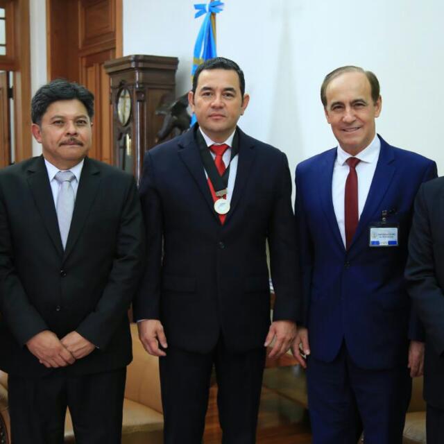 Guatemalan President Jimmy Morales, center, poses for a photo with Pastor Robert Costa, right, and his butler, left. During his March 13 visit, Pastor Costa gave President Morales an Ambassador of Peace medal.