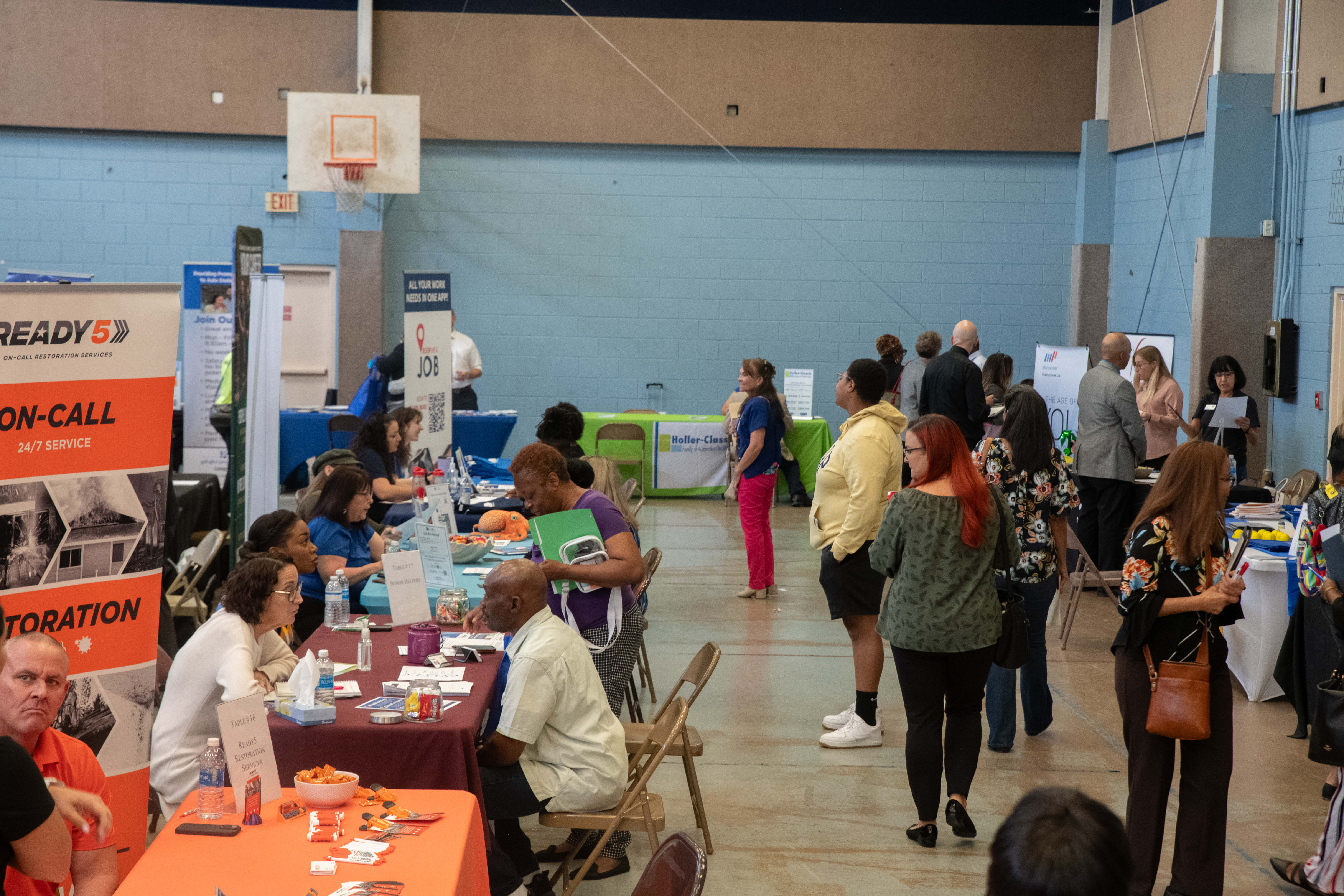 A busy job fair taking place in a gym