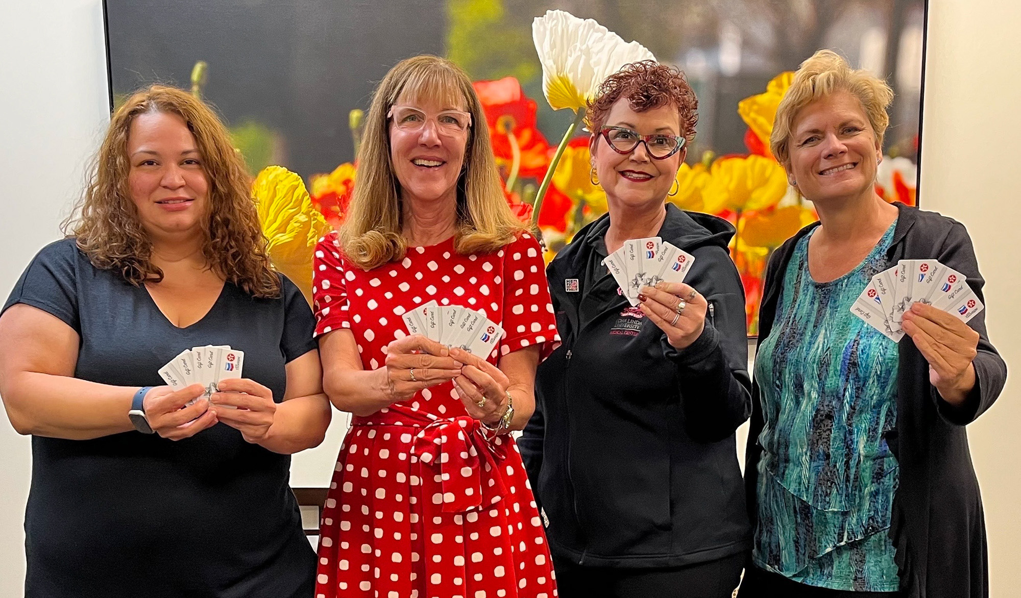 Loma Linda University Cancer Center team members hold up the gas cards they will be distributing to help support eligible patients in accessing critical cancer care.