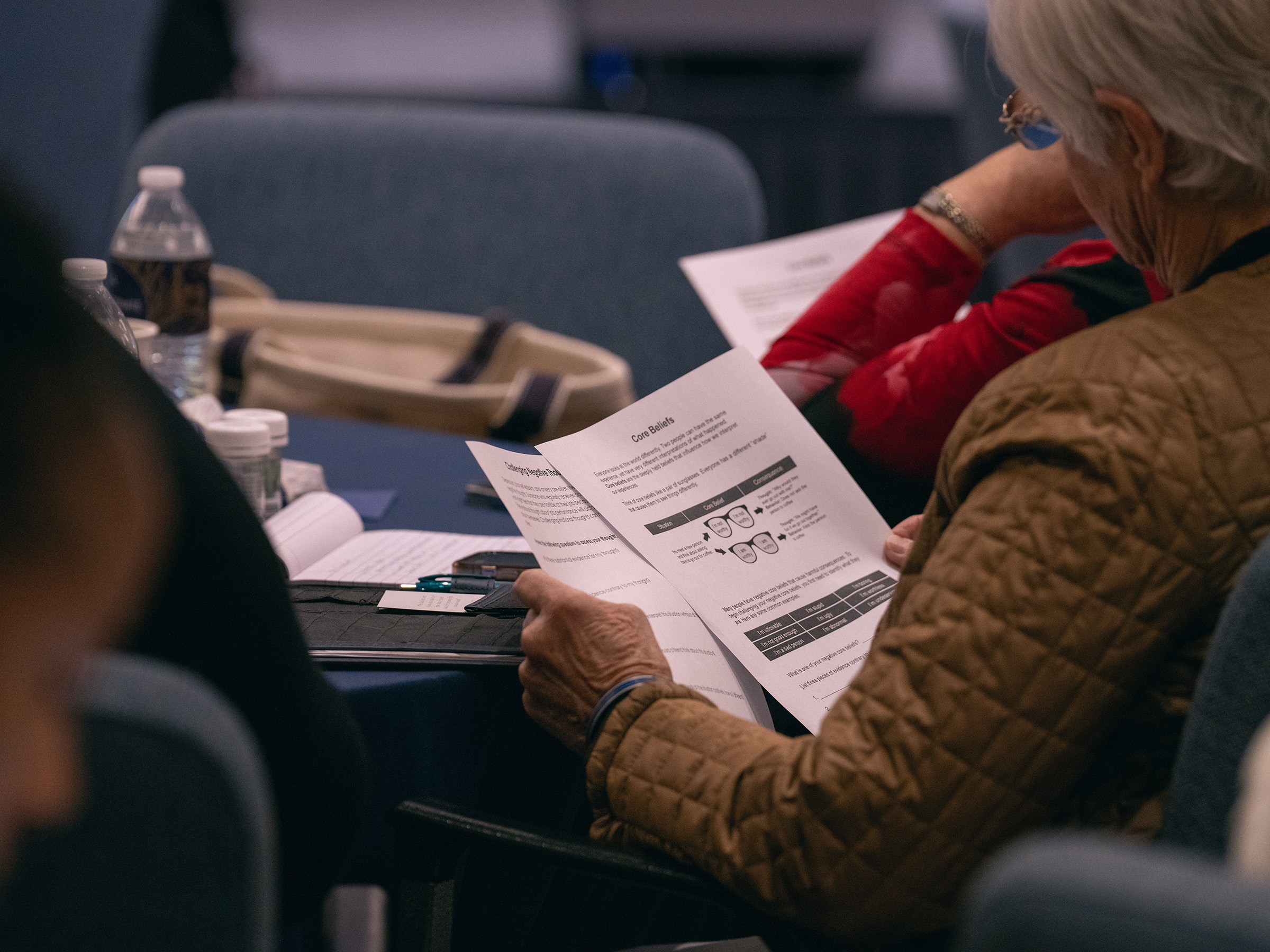 A woman sitting down at a conference table looks at papers reading core beliefs