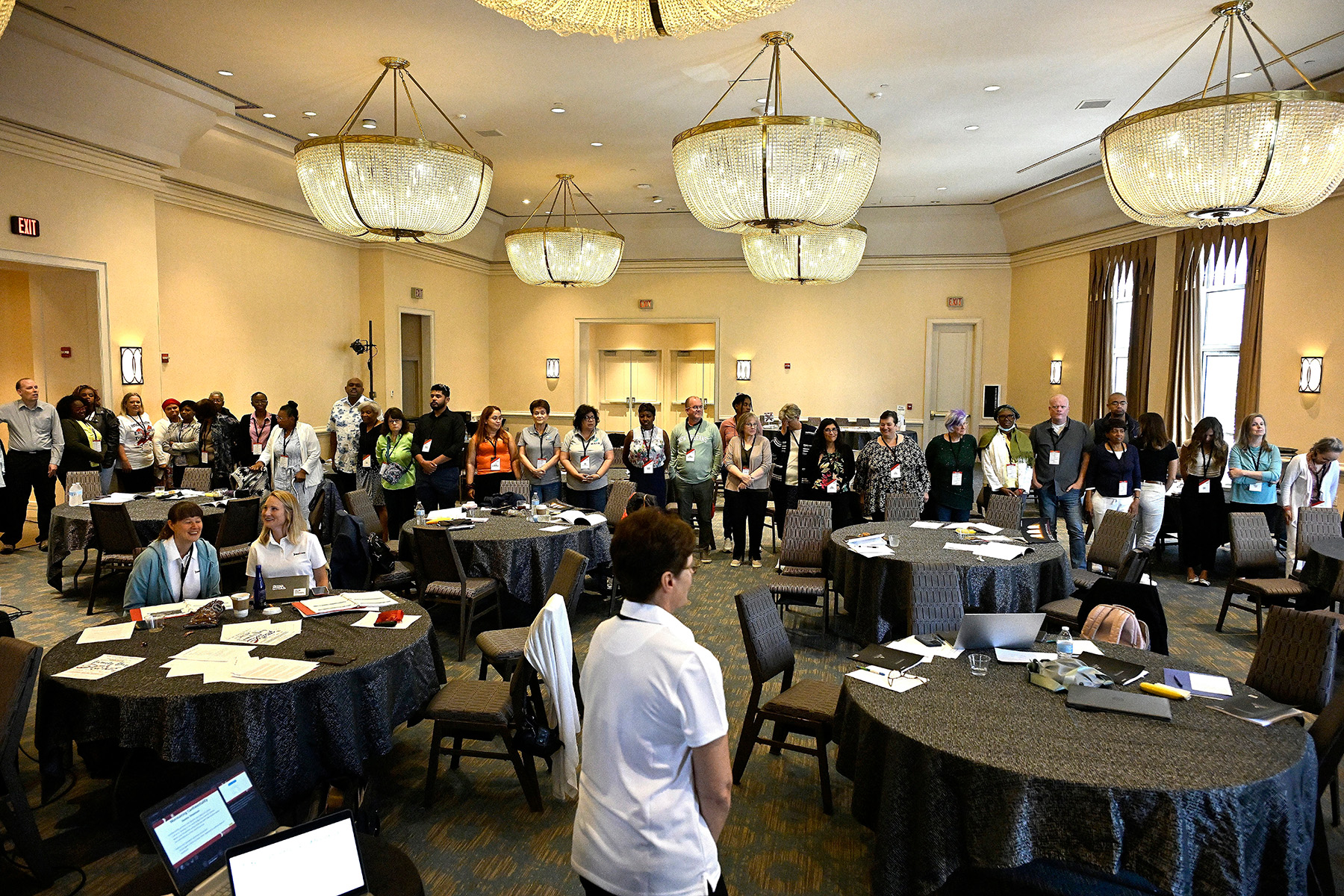 a group of people stand in a hotel room during a conference