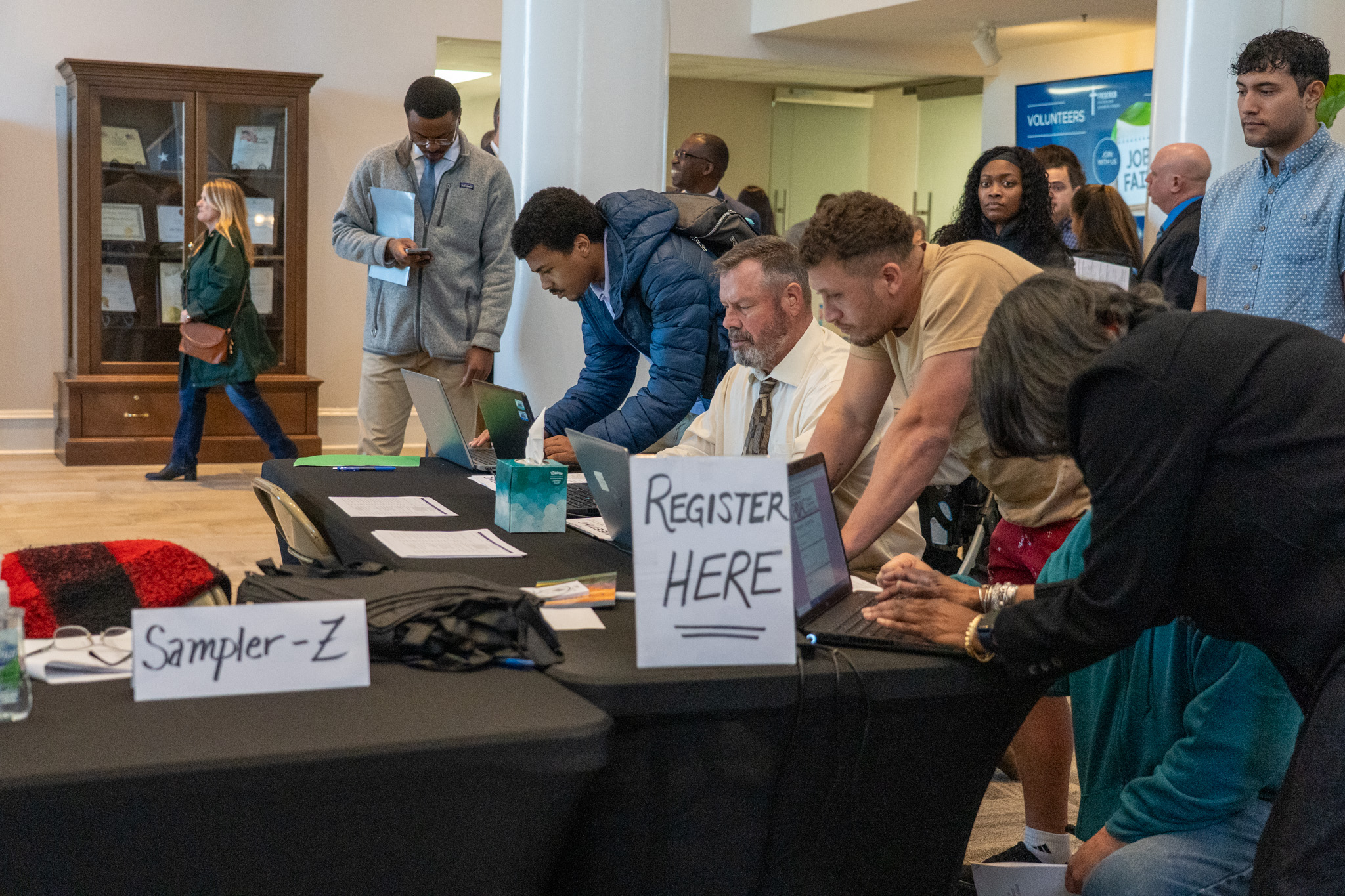 People crowd around a registration tables at a job fair held at Frederick Seventh-day Adventist Church.