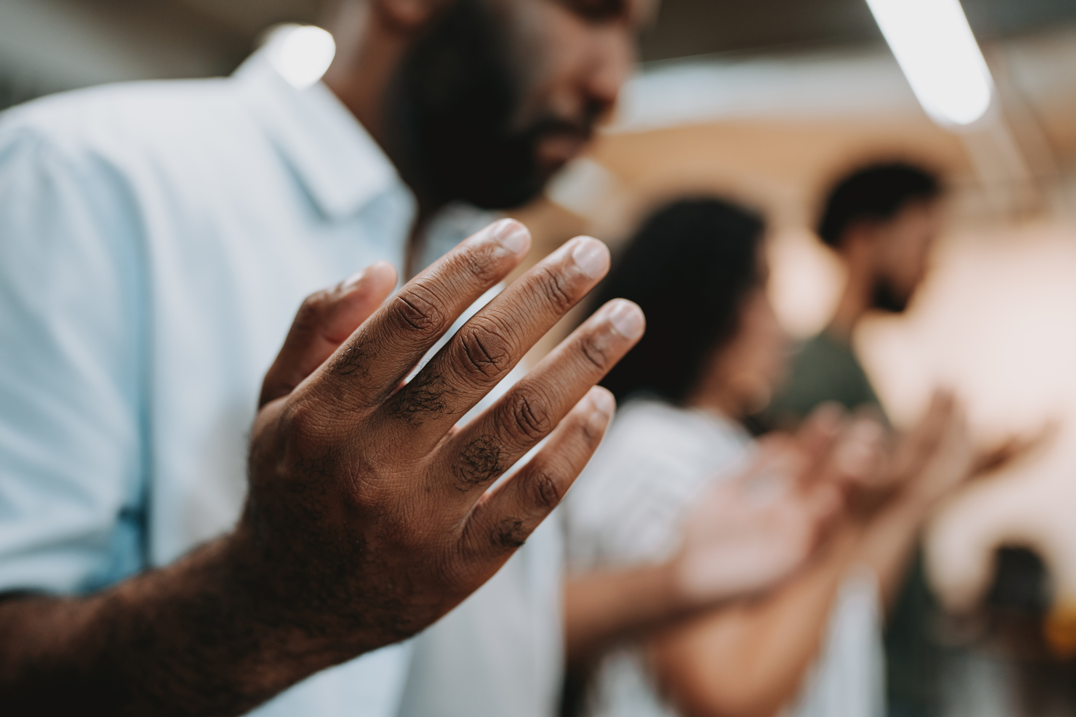 Photo of black man with group praying with open hands - Jacob Wackerhausen