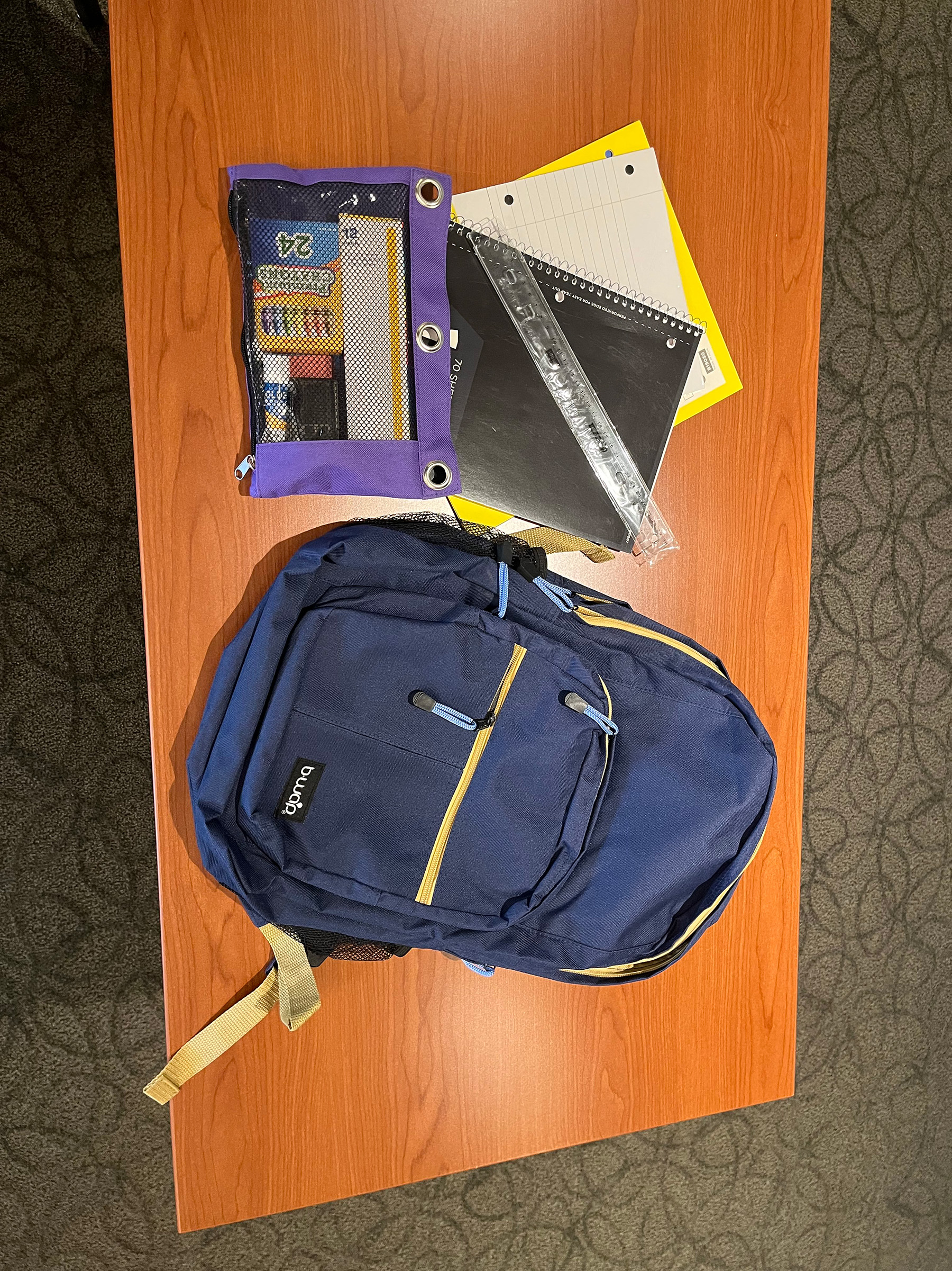 A photo of a backpack and school supplies laid out