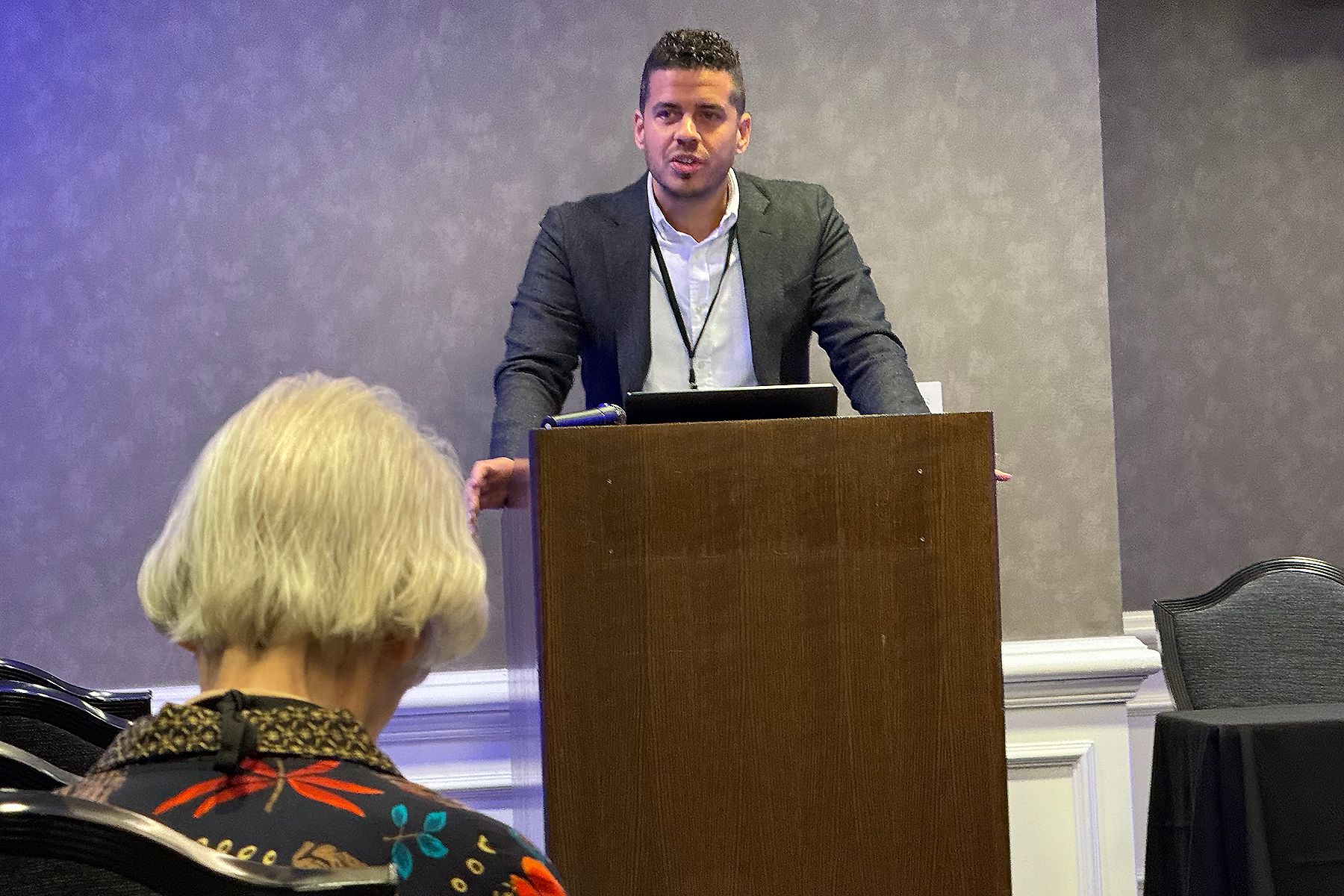 Hispanic man speaks at a podium