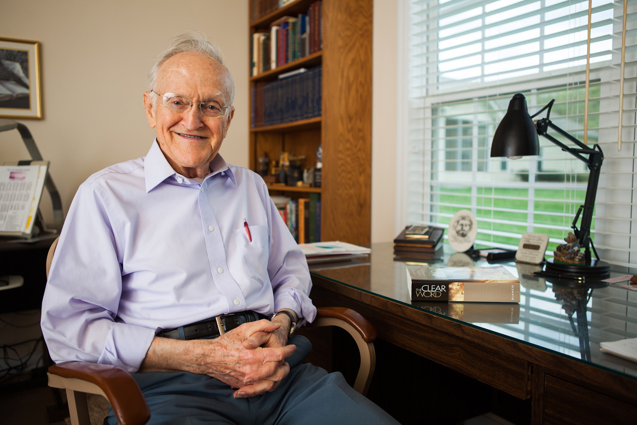 Jack J Blanco, elder caucasian white male, sitting at desk with The Clear Word Bible paraphrase. He is author of book.