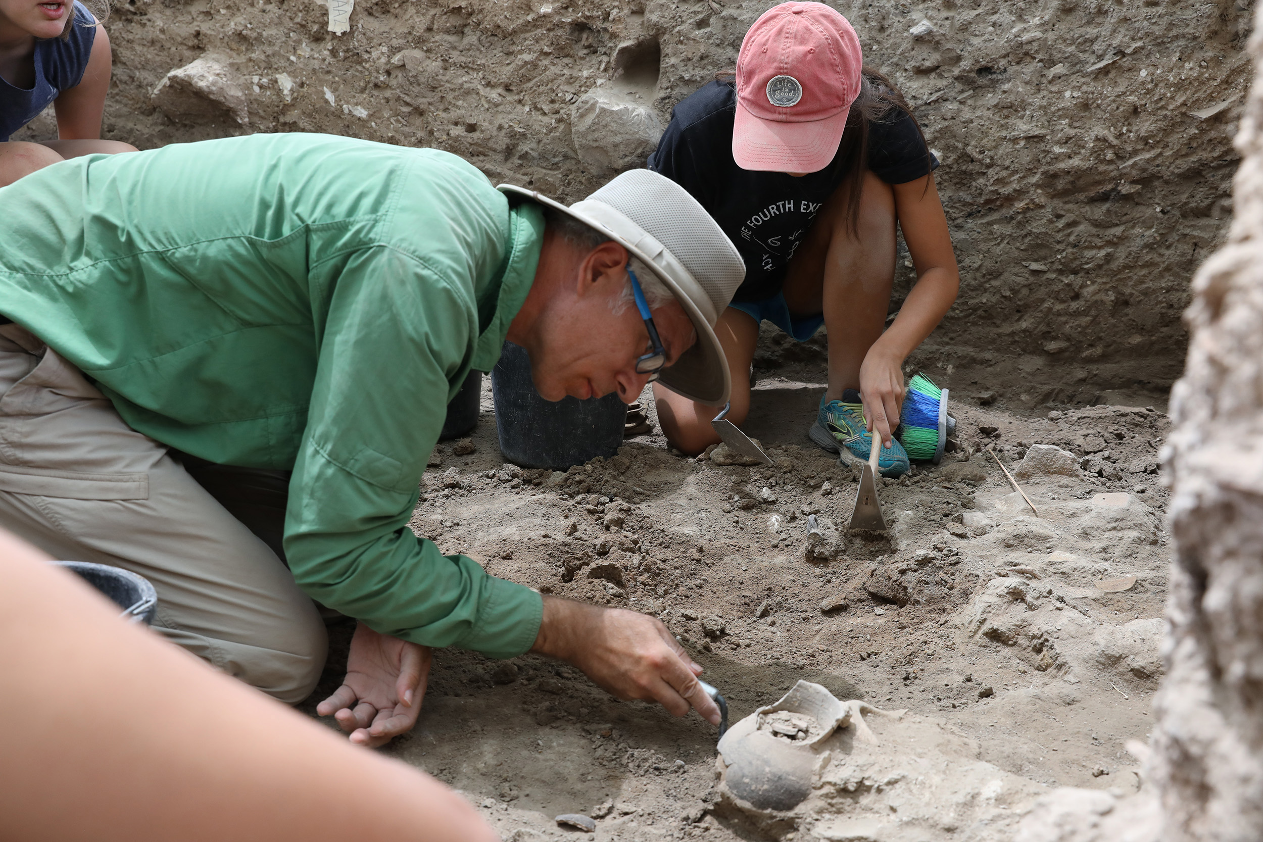 A man and woman in casual clothes on an archeological dig. 